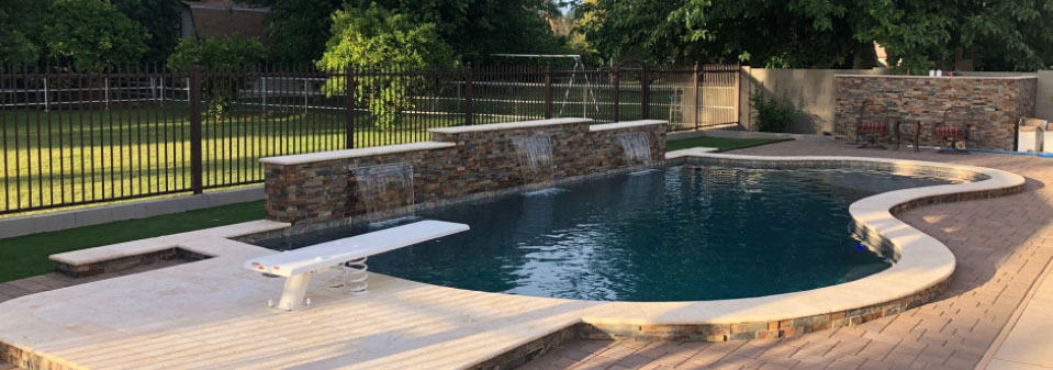 Phoenix pool installation with stone-accented wall and diving board