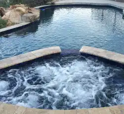 Custom-built outdoor spa connected to backyard pool in Phoenix