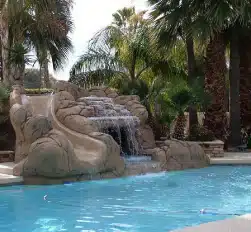 Custom Phoenix pool with integrated rock waterfall and water slide feature